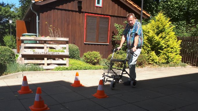 Siegfried Storch von der Verkehrswacht demonstriert die Durchfahrt einer engen Straße mit einem Rollator. | Fotos: Caritas